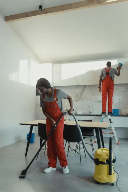 A couple packing marked boxes in a minimalist living room while preparing for moving day.